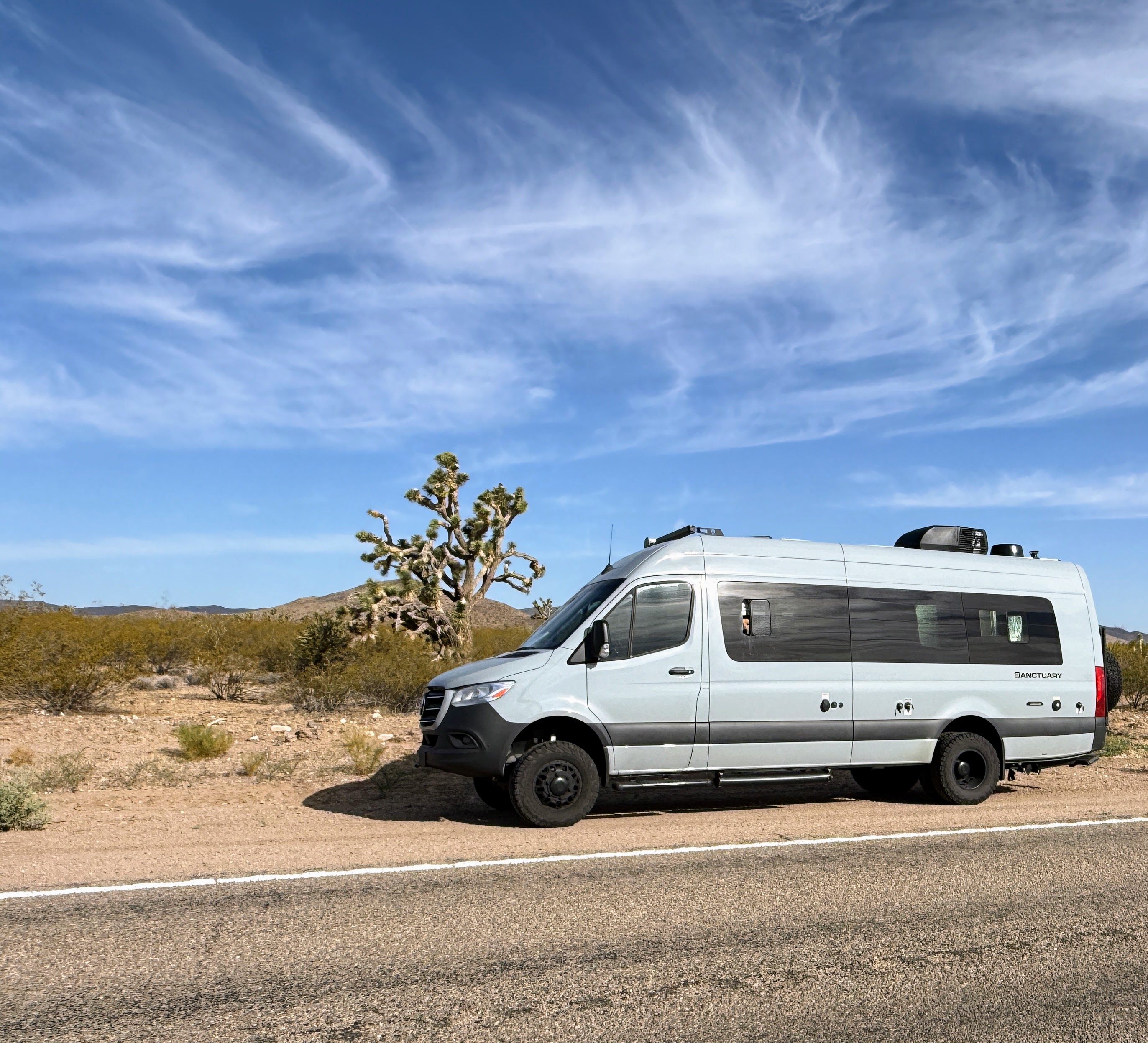 The van parked by a Joshua tree near Meadview