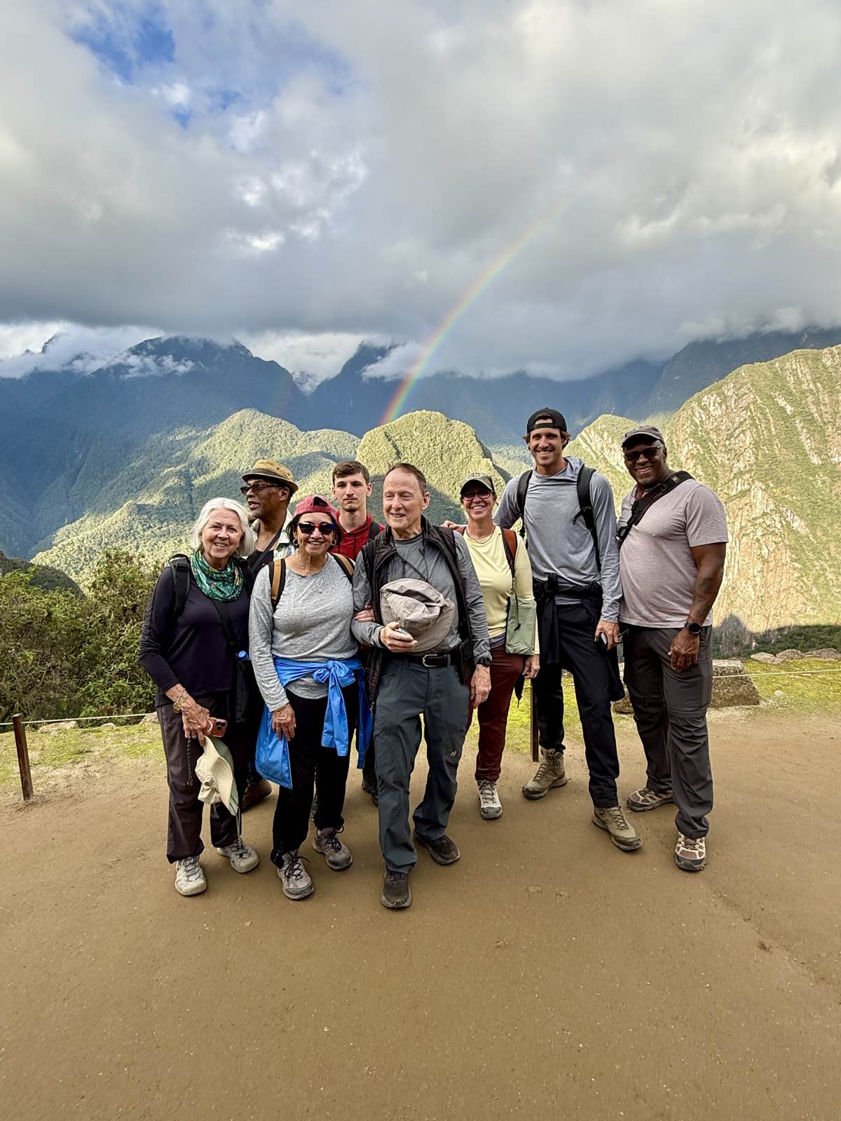 The tour group posing under a rainbow at Machu Picchu