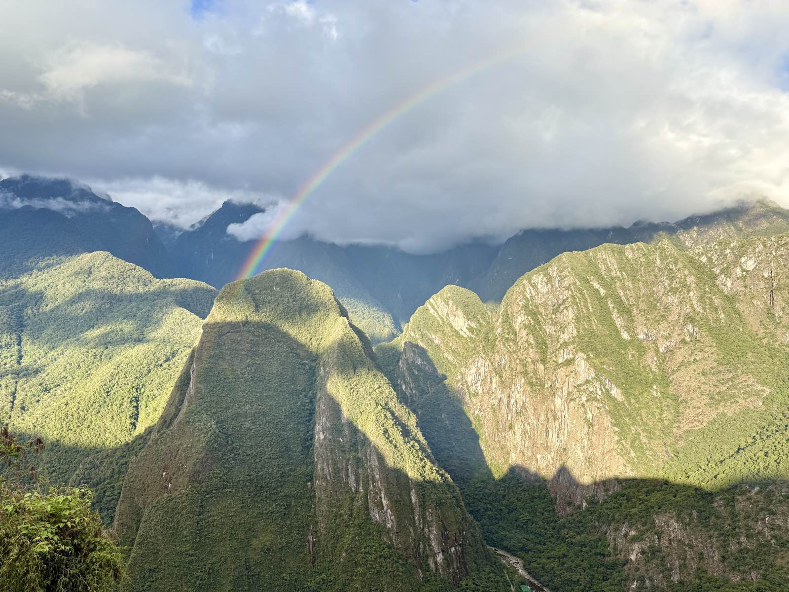 A rainbow arcing over green mountain peaks