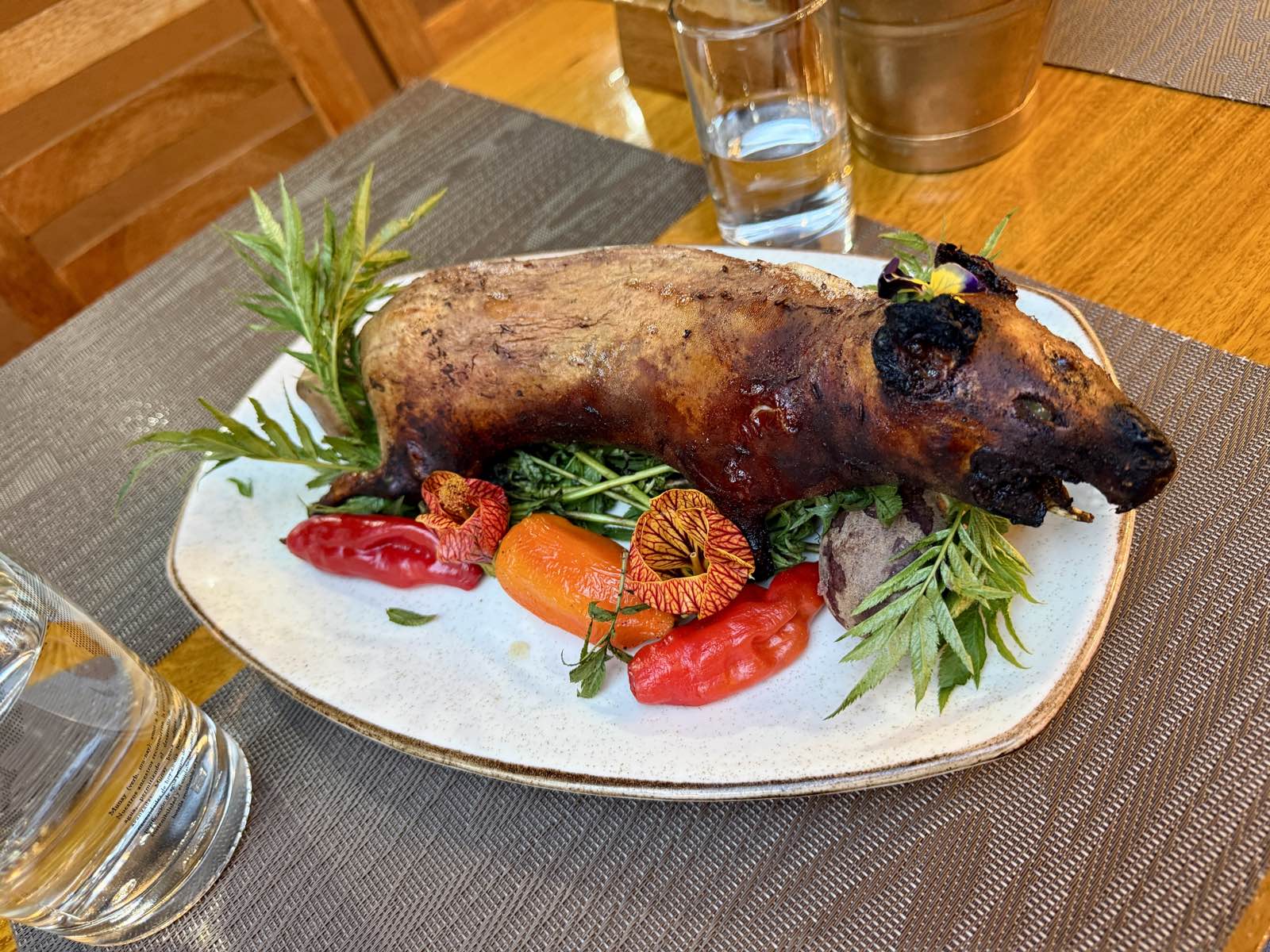 A whole roasted guinea pig served with peppers and herbs