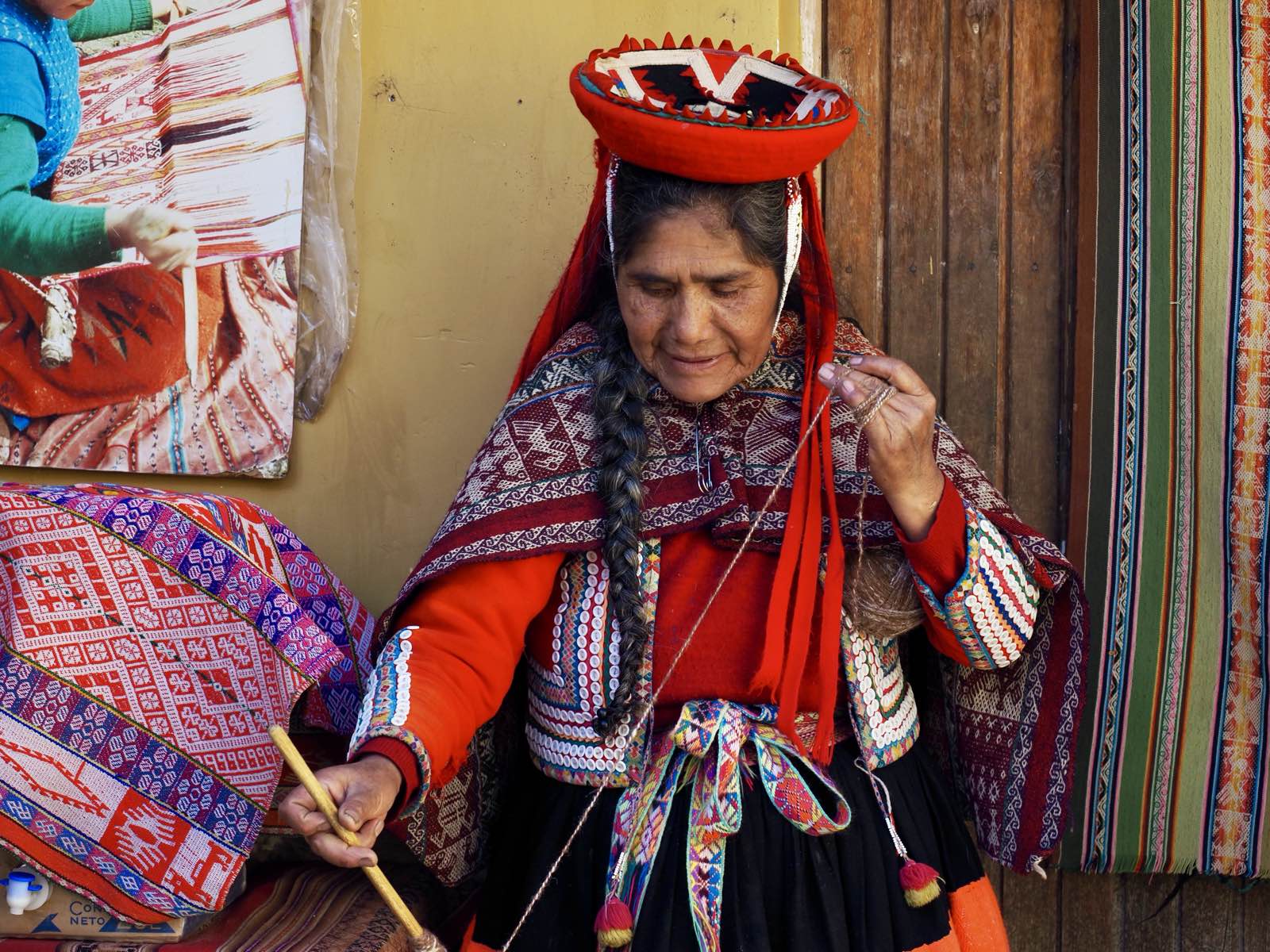 Rosetta spinning yarn by hand in her home