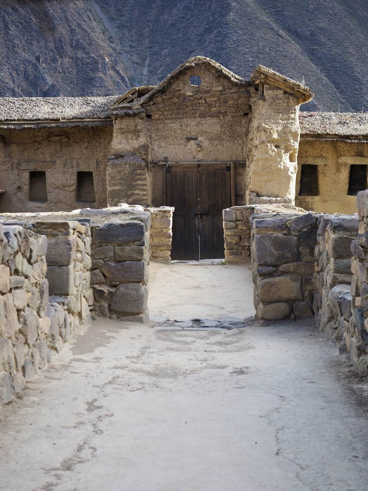 Stone walls framing a wooden gate at Ollantaytambo