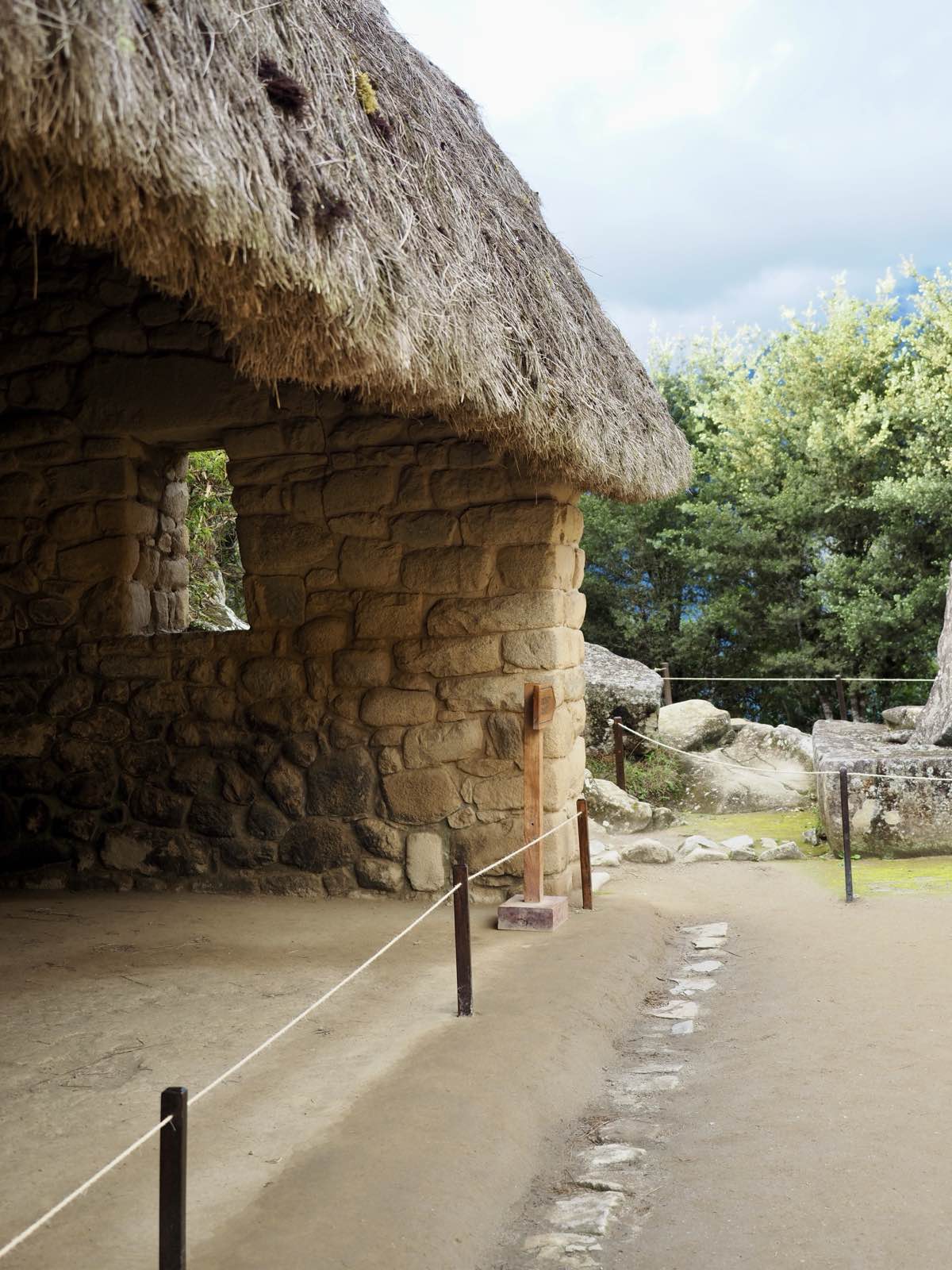 A restored stone house with a thatched roof inside the citadel
