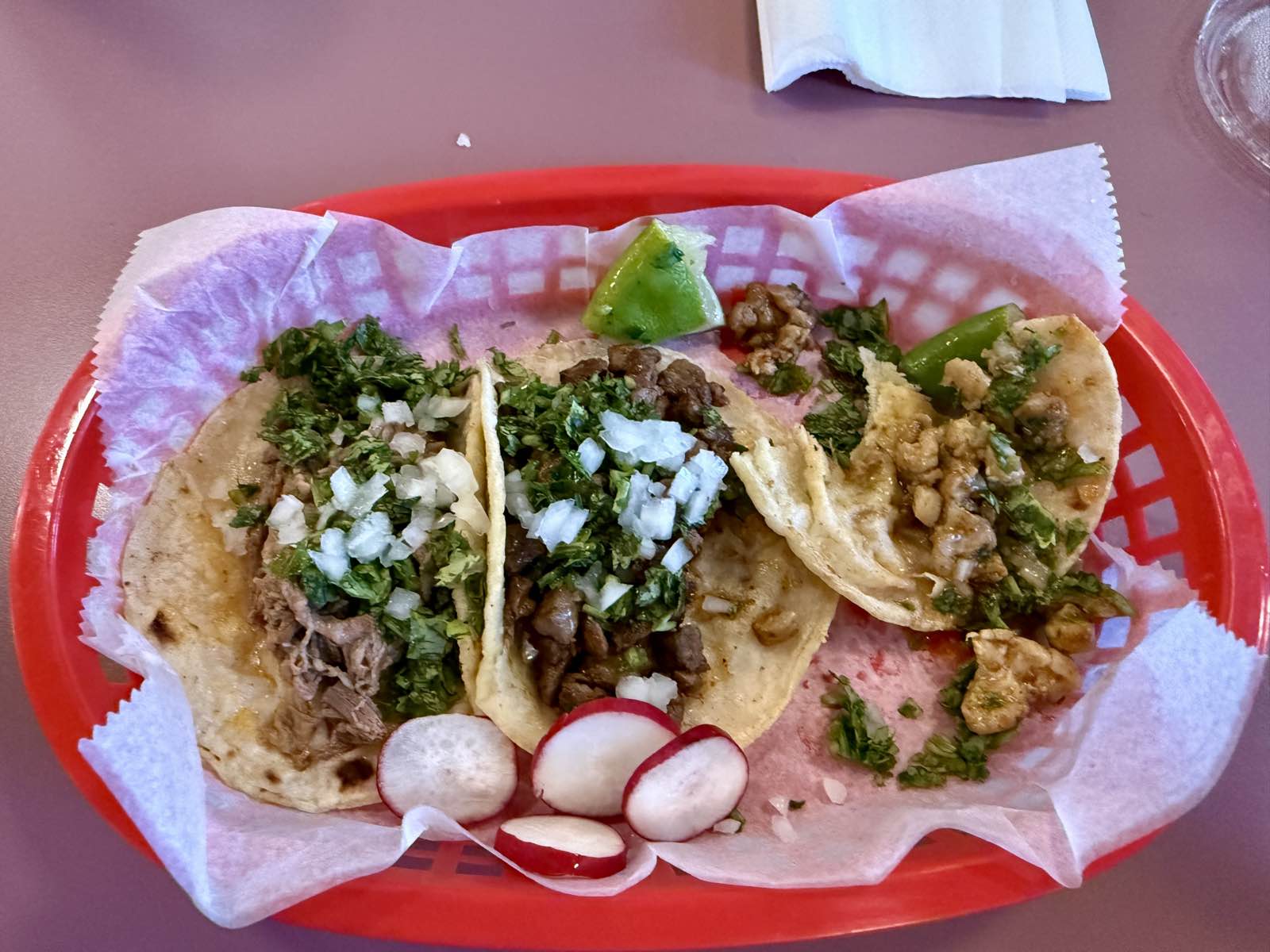 A plate of street tacos — asada, pollo, and barbacoa.